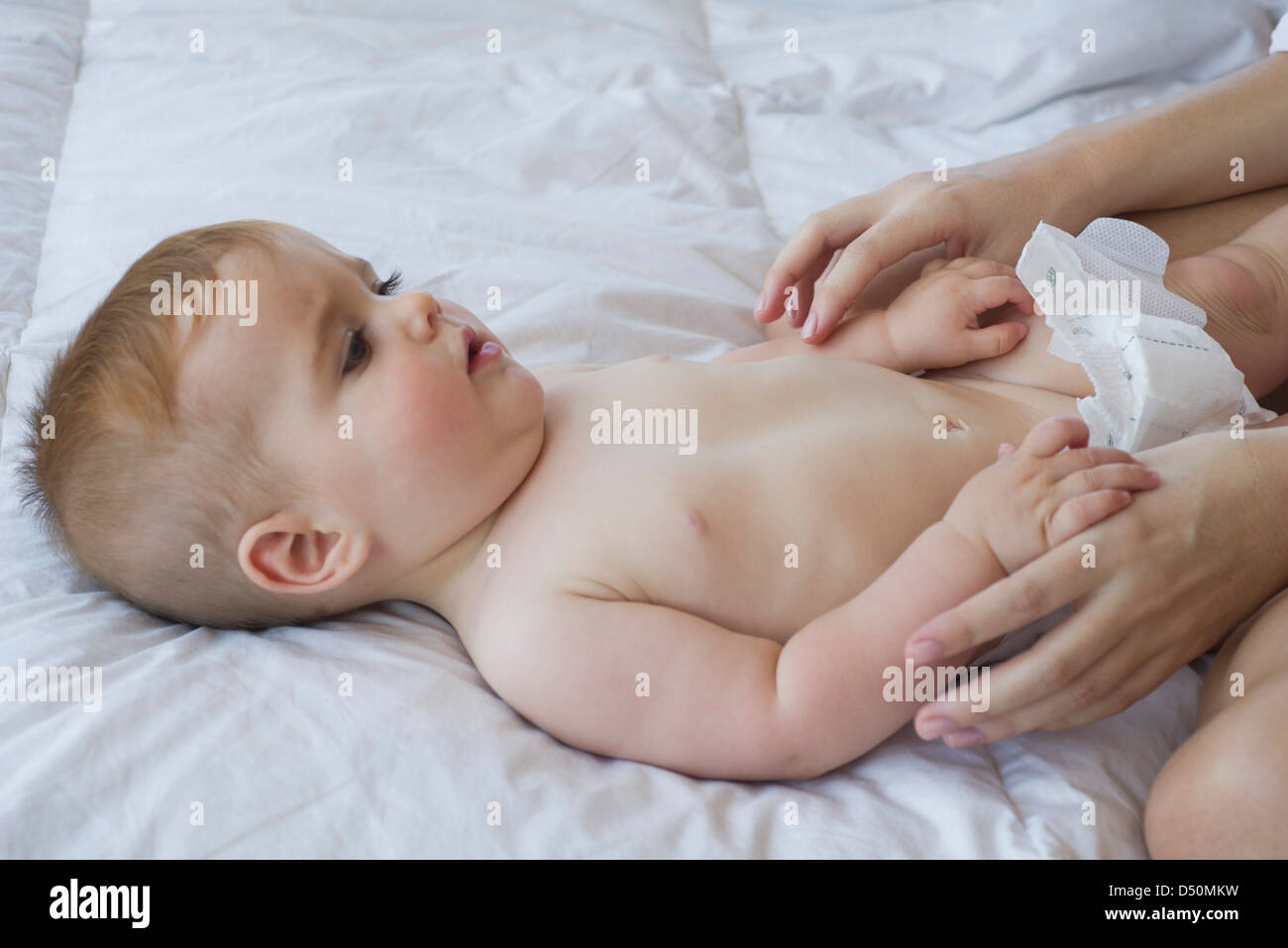 Il bambino sdraiato sulla schiena, azienda madre le dita Foto Stock