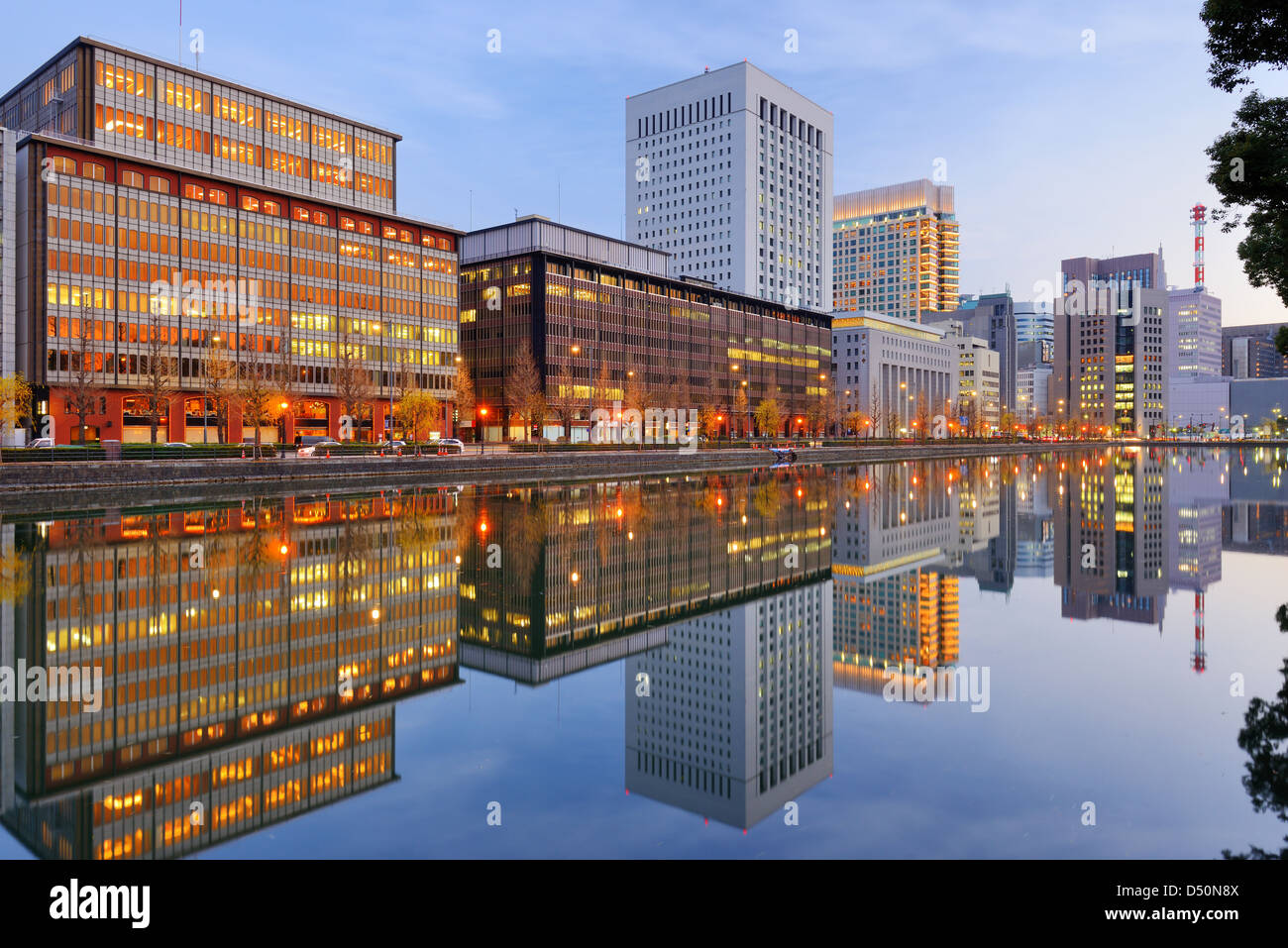 Punto di riferimento edifici riflettono fuori il Palazzo Imperiale fossato nel quartiere Marunouchi di Tokyo, Giappone. Foto Stock