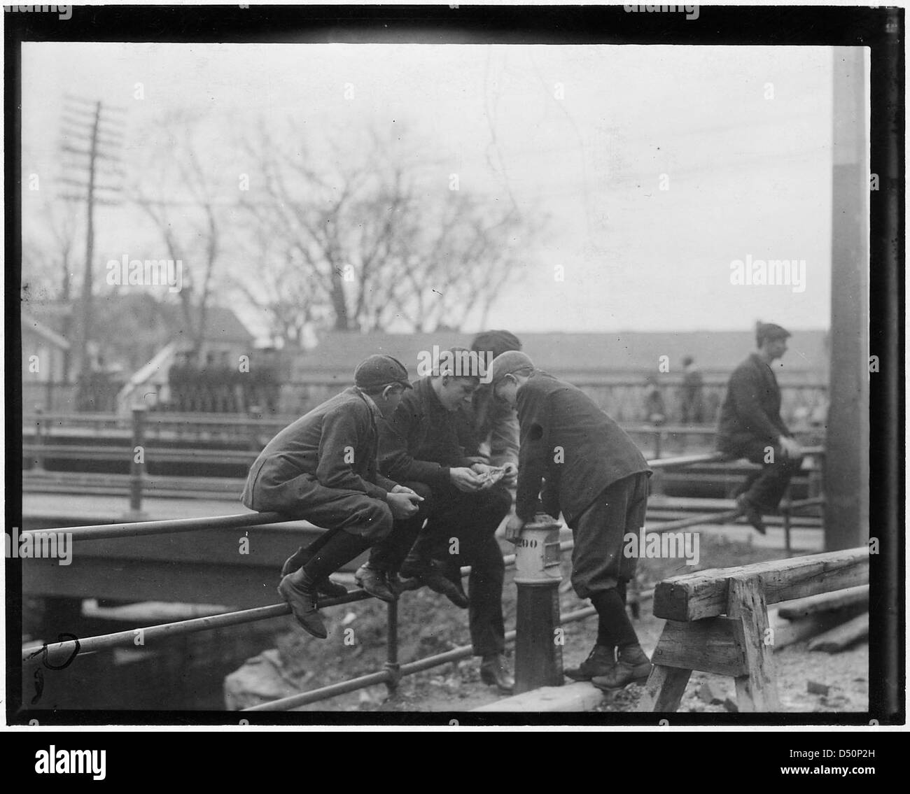 Questa foto di Lewis Hine del novembre 1910 mostra i ragazzi di mulini che giocano a una partita di carte durante la loro ora di mezzogiorno al Pacific Mills di Lawrence, Massachusetts, evidenziando le condizioni di lavoro minorile nell'America dei primi anni del XX secolo. Foto Stock