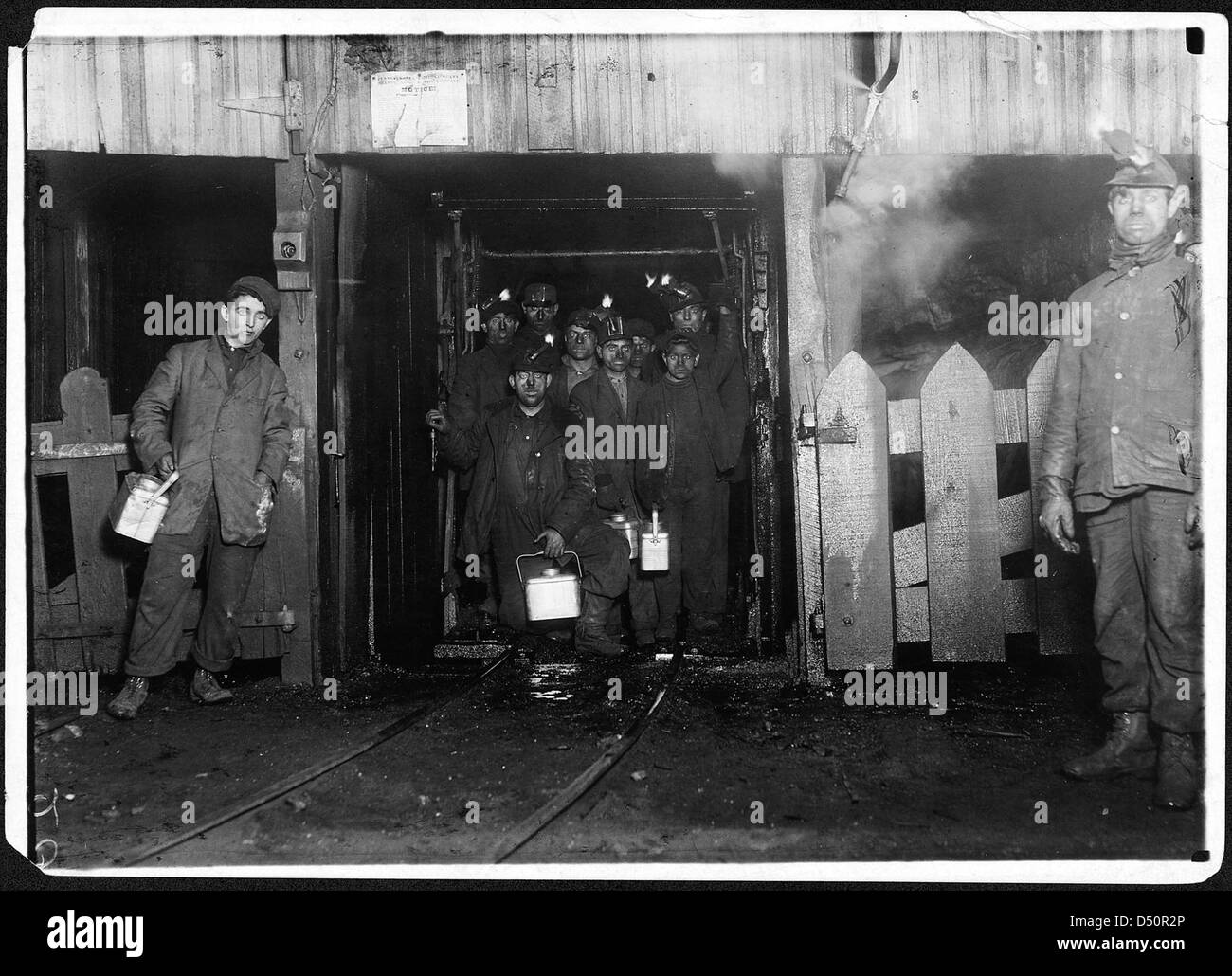Al termine della giornata. Attesa per la gabbia per andare verso l'alto. La gabbia è completamente aperta su due lati e non molto ben protetti su altri due, e di solito è affollata come questo, Gennaio 1911 Foto Stock
