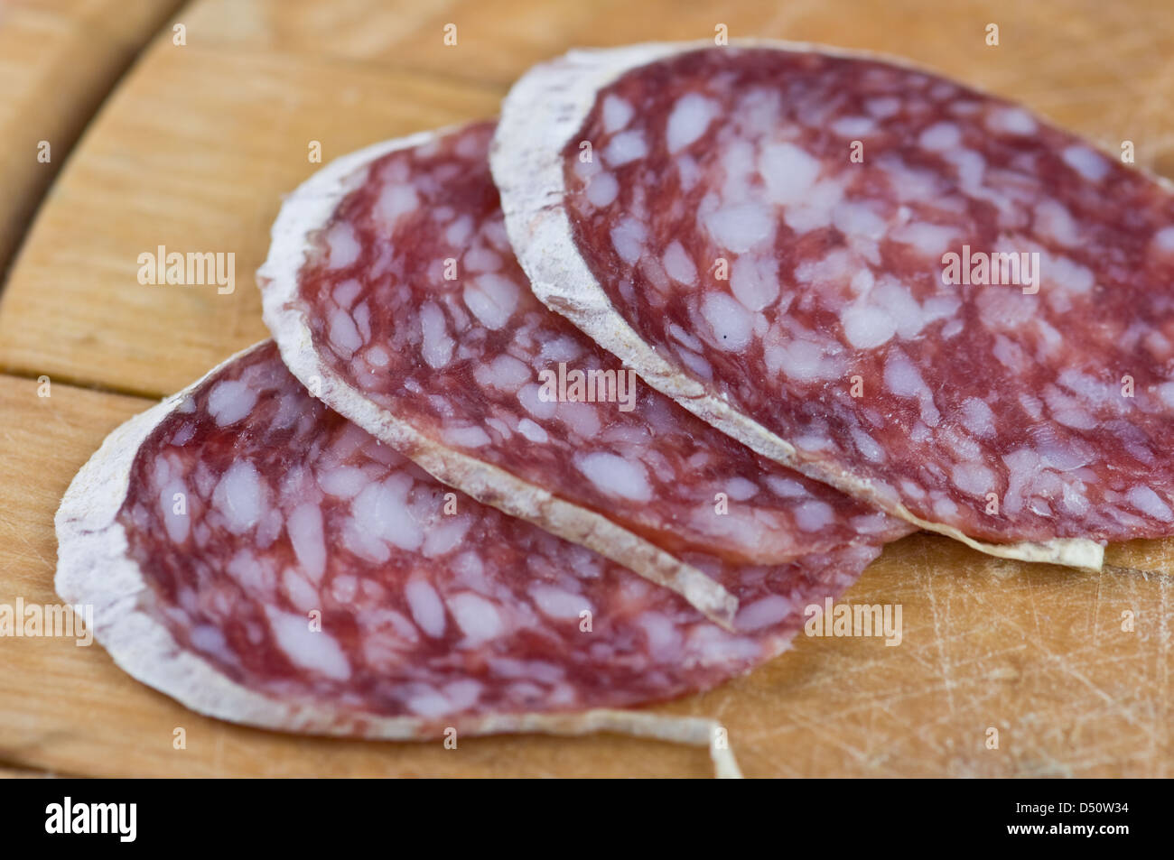 Salame di pezzi sul tavolo di legno Foto Stock
