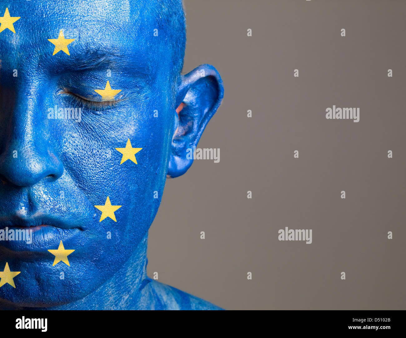 L'uomo con il suo volto dipinto con la bandiera dell'Unione europea. L'uomo è chiuso gli occhi e composizione fotografica lascia solo metà Foto Stock