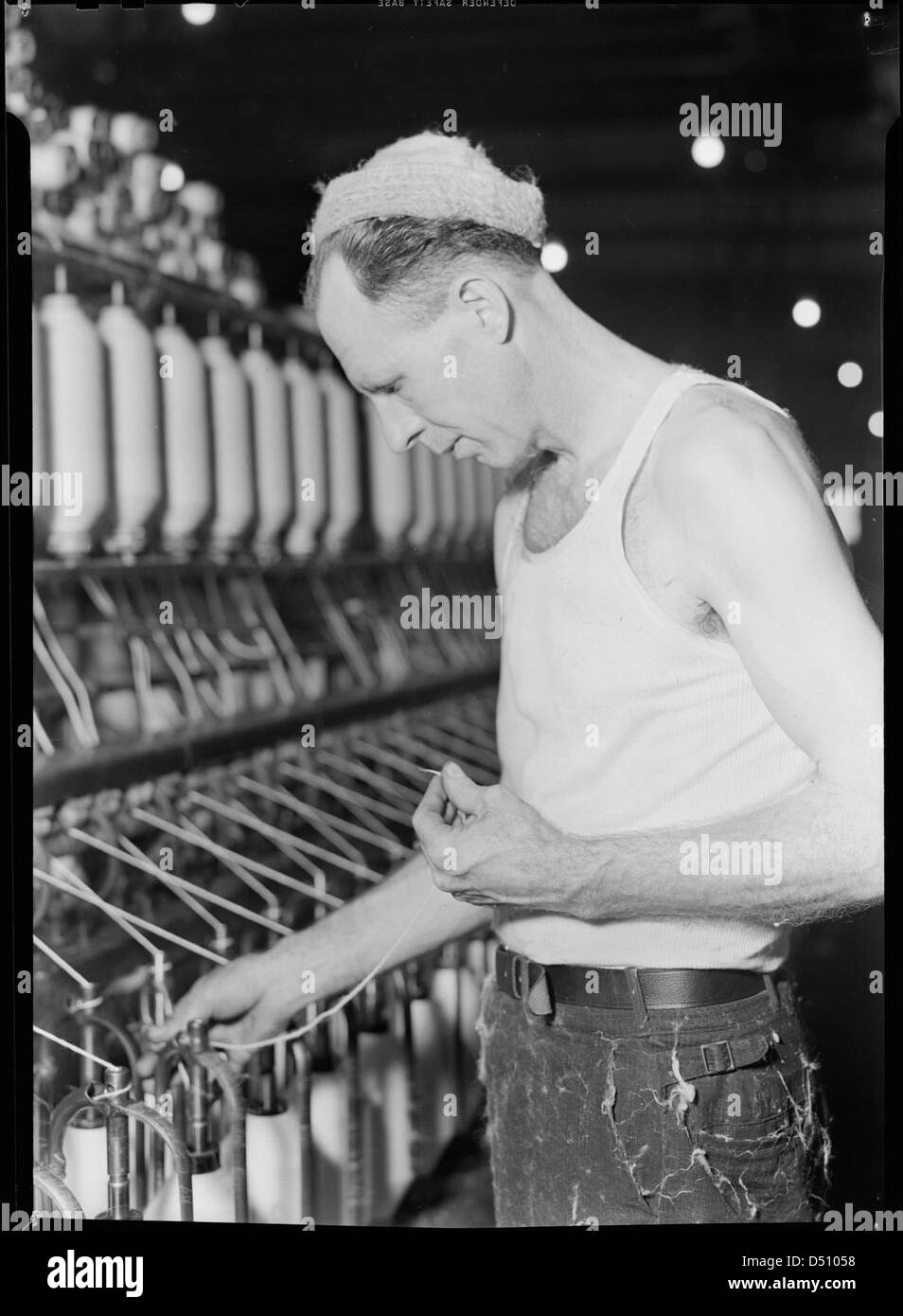 Una fotografia del gennaio 1937 mostra un lavoratore semi-qualificato noto come un "lubber" che gestisce una macchina in una fabbrica di High Point, Carolina del Nord, durante la grande depressione. Questa immagine evidenzia le difficili condizioni di lavoro del tempo. Foto Stock