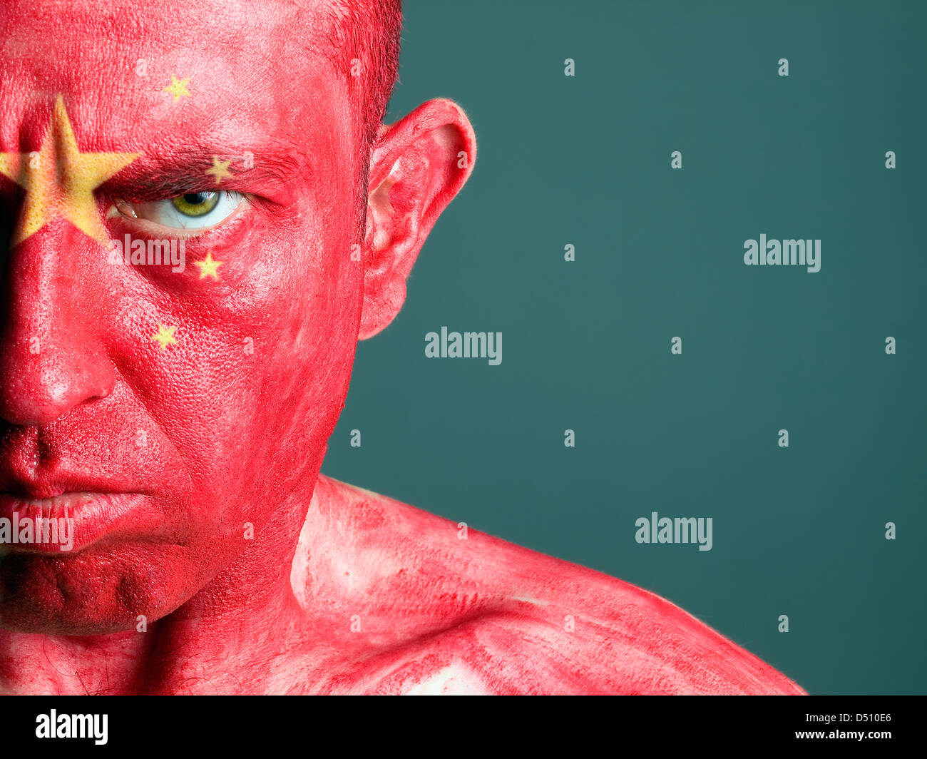 L'uomo con il suo volto dipinto con la bandiera della Cina. L'uomo è grave e composizione fotografica lascia solo metà della faccia. Foto Stock