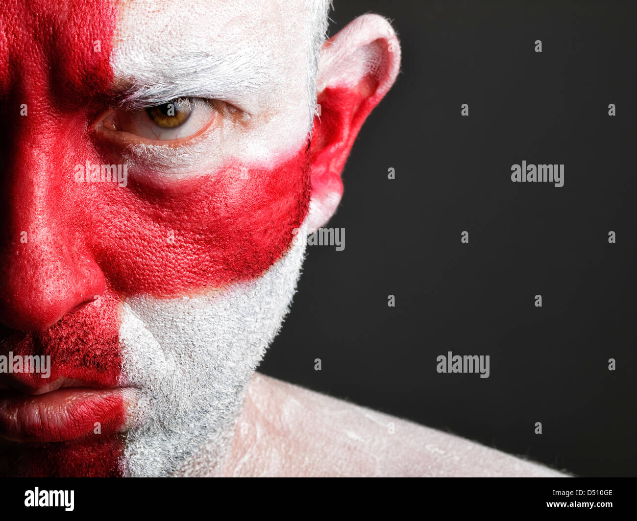 L'uomo con il suo volto dipinto con la bandiera dell'Inghilterra. L'uomo è grave e composizione fotografica lascia solo metà della faccia Foto Stock