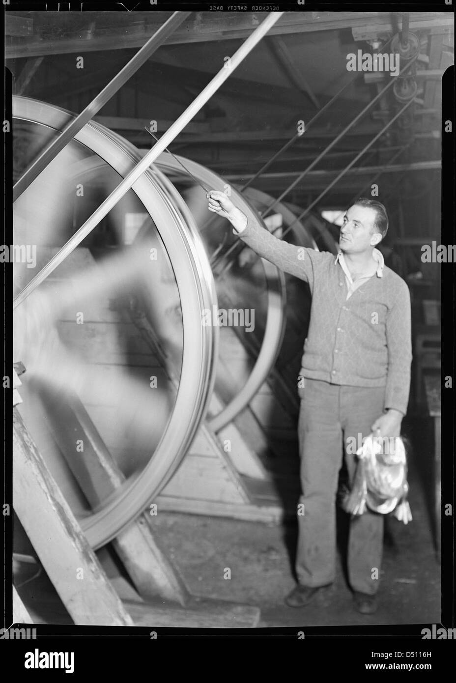 Lana di vetro. Frederick e Dimmock Co. Questo mostra l'operaio che ha trascinato il vetro dall'altro lato della stanza su una ruota, marzo 1937 Foto Stock