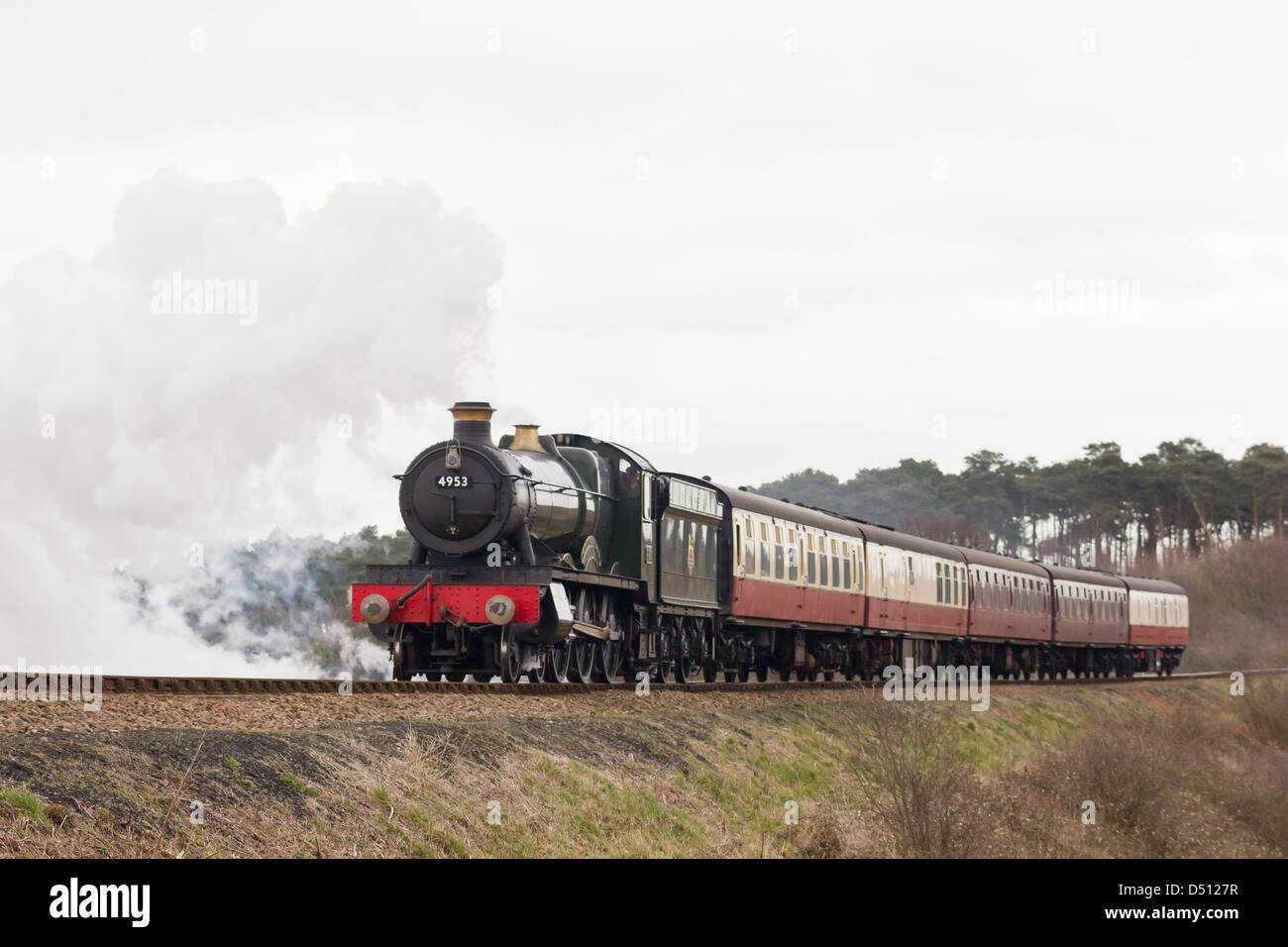 Una locomotiva a vapore la trazione di un treno passeggeri sul Nord Stazione di Norfolk, Inghilterra Foto Stock