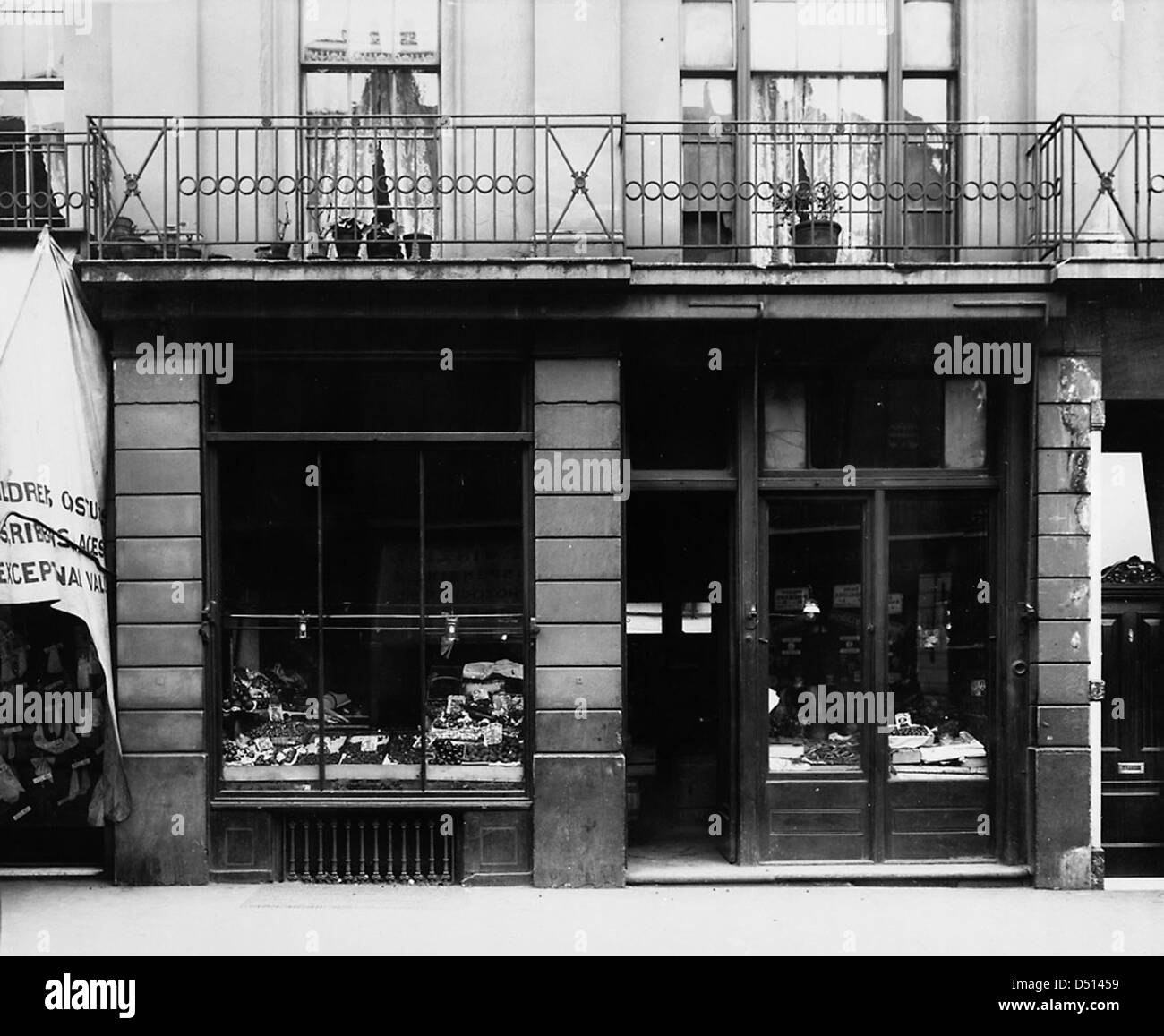 Questa fotografia del 1910 circa cattura uno shopping su Nelson Road a Greenwich, Londra. L'immagine mette in evidenza la vetrina, i beni in vendita e l'aspetto generale di un'azienda locale all'inizio del XX secolo. Foto Stock