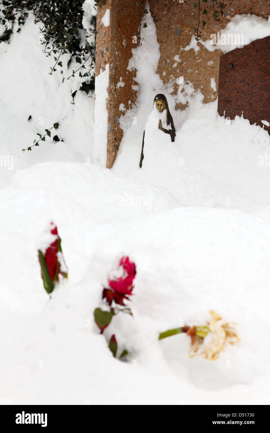 Feld am See, Austria, inviato schneiter tomba di pietra e fiori nella neve nel cimitero di Feld am See Foto Stock