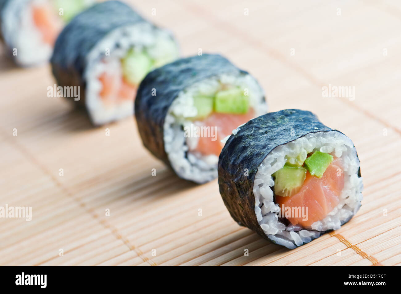 Sushi in fila sul tappetino di bambù Foto Stock