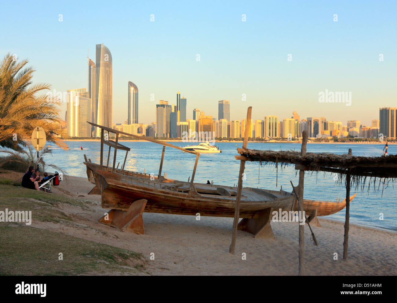 Sambuco tradizionale sulla spiaggia, alti edifici moderni in background, Abu Dhabi Heritage Village, Emirati Arabi Uniti Foto Stock
