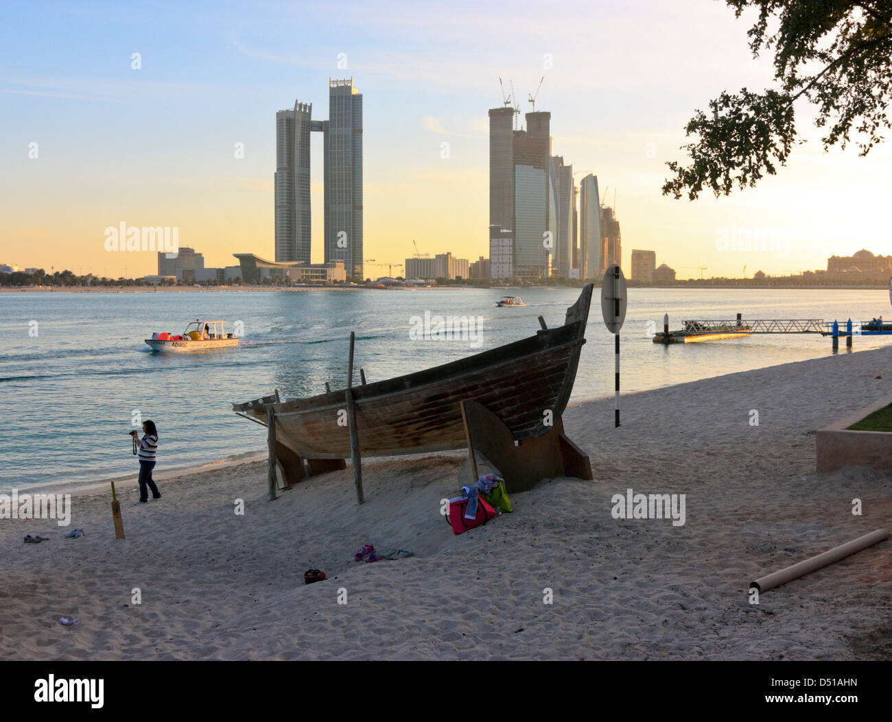 Sambuco tradizionale sulla spiaggia, alti edifici moderni in background, Abu Dhabi Heritage Village, Emirati Arabi Uniti Foto Stock