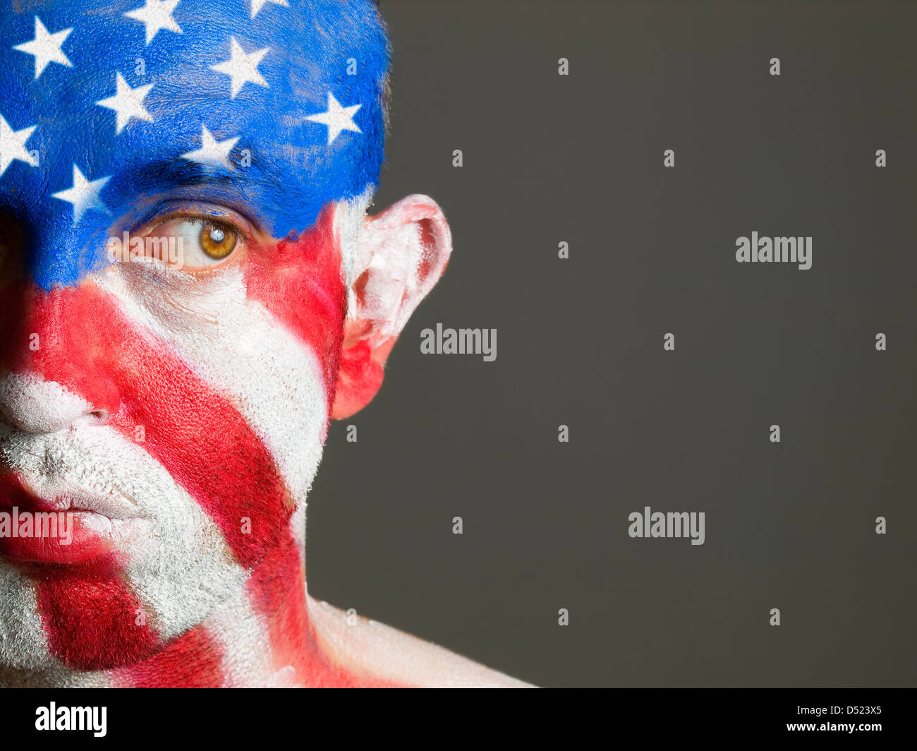 L'uomo con il suo volto dipinto con la bandiera degli Stati Uniti d'America. L'uomo è alla ricerca di lato e composizione fotografica lascia solo metà del Foto Stock