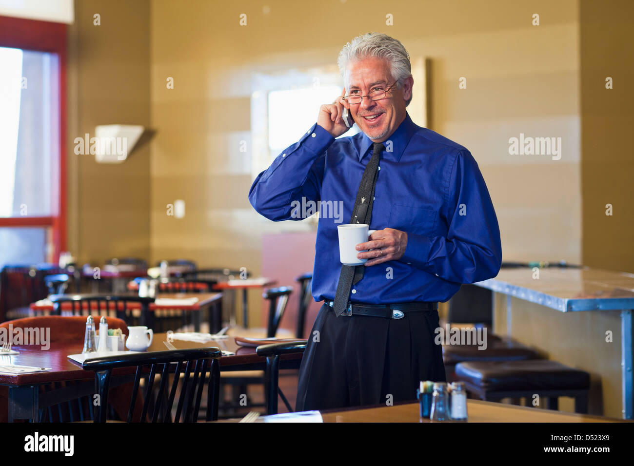 Cafe ispanica proprietario parlando al cellulare Foto Stock