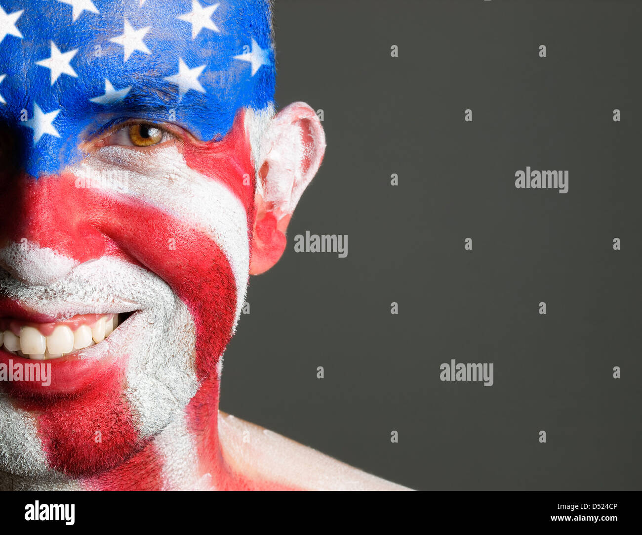 L'uomo con il suo volto dipinto con la bandiera degli Stati Uniti d'America. L'uomo è sempre sorridente e composizione fotografica lascia solo metà della faccia. Foto Stock