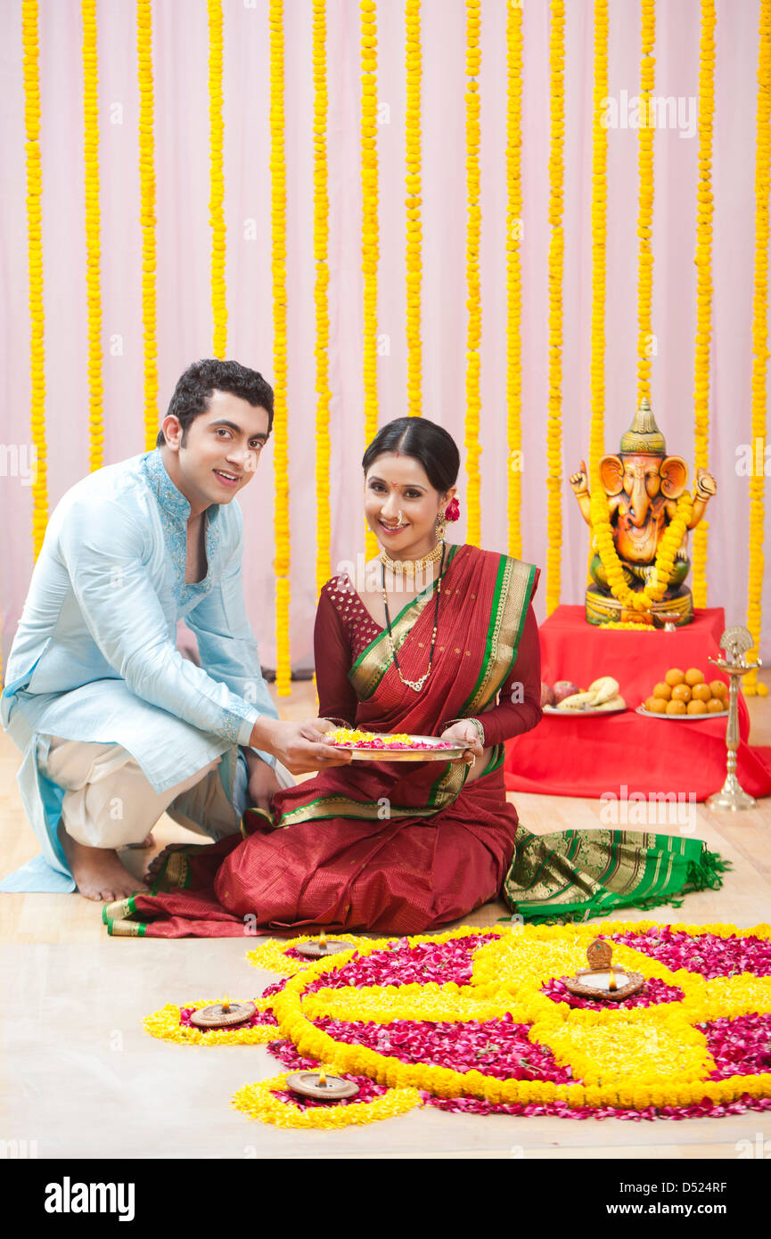 Maharashtrian giovane rendendo flower rangoli durante ganesh chaturthi festival Foto Stock