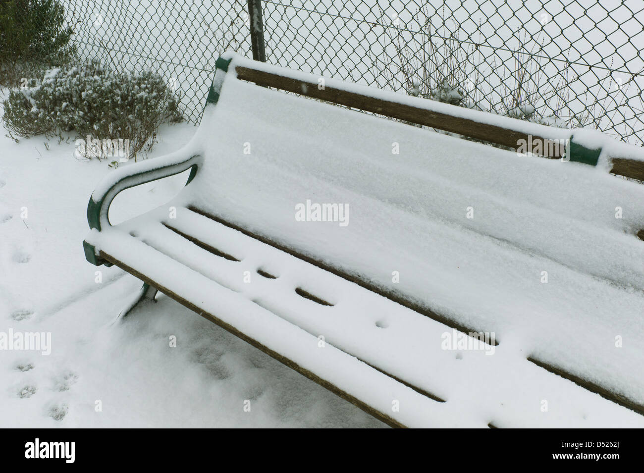 Coperta di neve una panchina nel parco, Brighton, Regno Unito Foto Stock