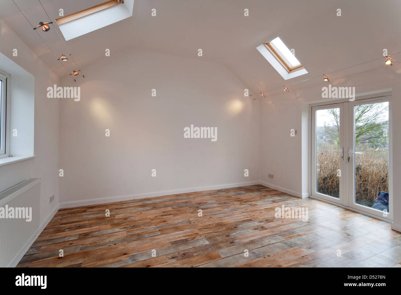 Un nuovo grande vuoto verniciato bianco soffitto alto stanza vuota con lucernari velux. Foto Stock