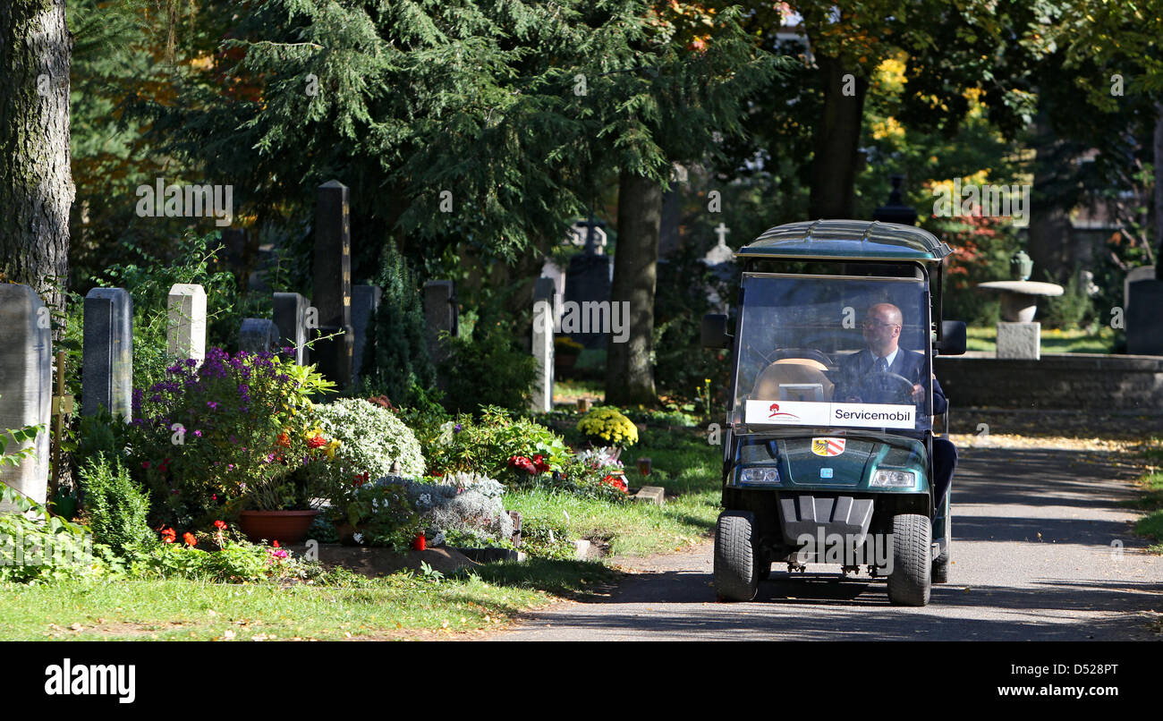 Ein Mitarbeiter des Westfriedhofs in Norimberga (Mittelfranken) fährt auf einem Golfkart über das Friedhofsgelände (Foto vom 08.10.2010). Die Waldgrünen Golfkarts warten auf dem Westfriedhof in Nürnberg auf Besucher. Mit den Servicemobilen fahren Mitarbeiter der Friedhofsverwaltung ältere und gebrechliche Hinterbliebene zu den Gräbern, così der Leiter der Nürnberger Friedhofsverwaltung Foto Stock