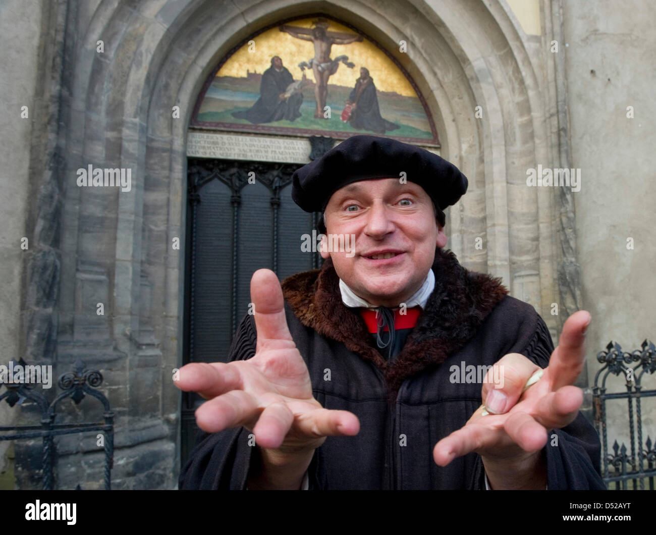 Attore Nernhard Naumann, vestito come Martin Lutero (1483-1546), parla di fronte alla famosa porta della chiesa del castello a Wittenberg (Germania), 31 ottobre 2010. Secondo deliverances, Martin Lutero mise il suo 95 tesi contro la vendita di indulgances alla porta della chiesa il 31 ottobre 1517. Questo è detto di essere l'inizio del mondiale per la riforma della chiesa. Foto: Foto Stock