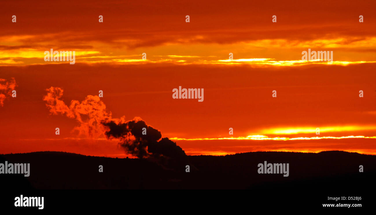 Il sole sorge dietro le montagne della regione di Spessart e l'enorme nube di fumo eminated dalle centrali elettriche a carbone Staudinger nella distanza in Grosskrotzenburg, nei pressi di Francoforte, Germania, 27 ottobre 2010. Foto: Frank Rumpenhorst Foto Stock