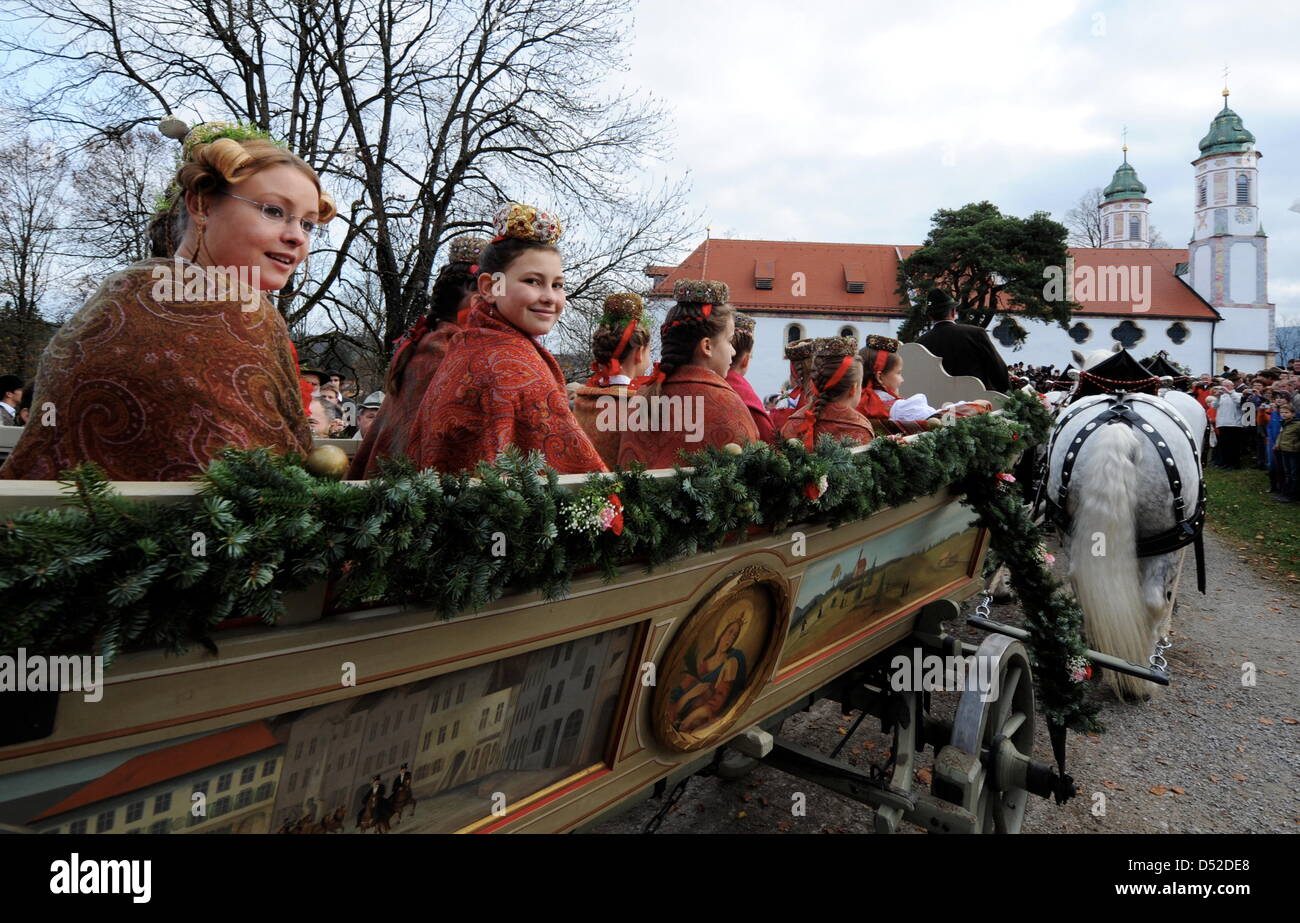 Mädchen mit Trachten sitzen am Samstag (06.11.2009) bei der traditionellen Leonhardifahrt auf den Kalvarienberg in Bad Tölz (Alta Baviera) auf einem dekorierten Pferdewagen und fahren auf die Heilig-Kreuz-Kirche zu. Die Brauchtumsveranstaltung wird zu Ehren des patrons der Stalltiere in vielen bayerischen Orten begangen. Foto: Tobias Hase dpa/lby Foto Stock