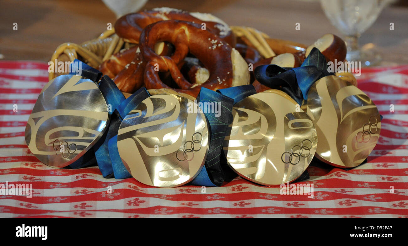 Le quattro medaglie d argento del paese sci cross donna 4x5 Relè Classic/Free membro della squadra Katrin Zeller, Evi Sachenbacher-Stehle, Miriam Gossner e Claudia Nystad di Germania giacciono su un tavolo al ' Deutsches Haus' in Whistler durante il Vancouver 2010 Giochi Olimpici, Canada, 25 febbraio 2010. Foto: Peter Kneffel +++(c) dpa - Bildfunk+++ Foto Stock