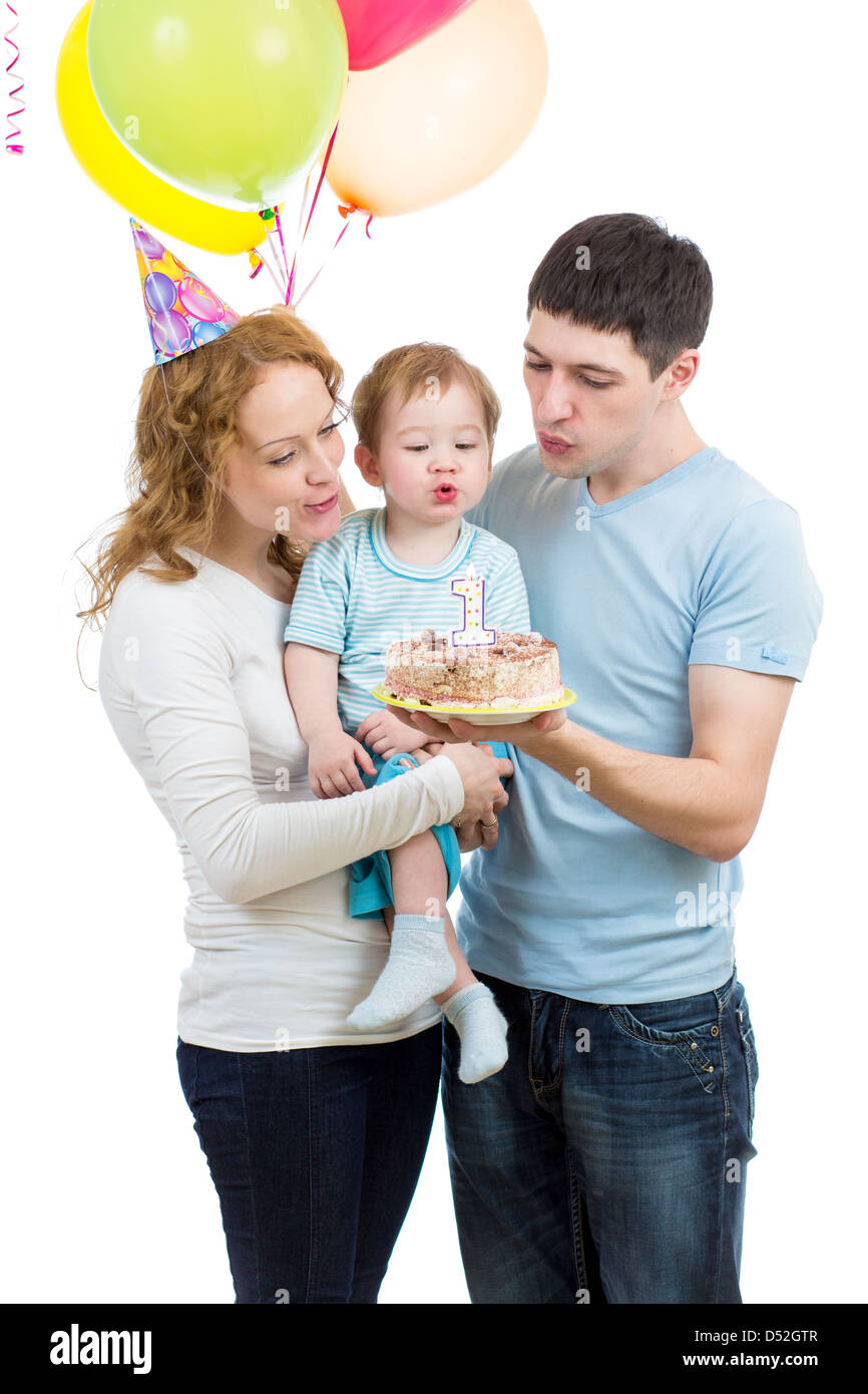 Il capretto con i genitori festeggia il compleanno e soffiaggio di candele sulla torta Foto Stock