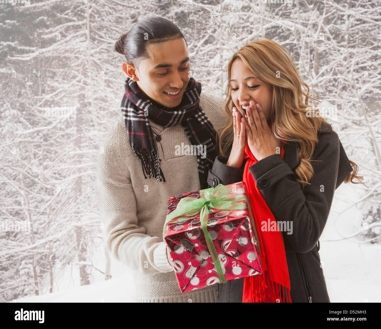 L uomo dando ragazza dono nella neve Foto Stock