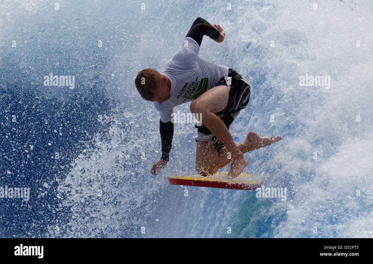 Un surfista cavalca un onda in palma de mallorca's Beach Foto Stock