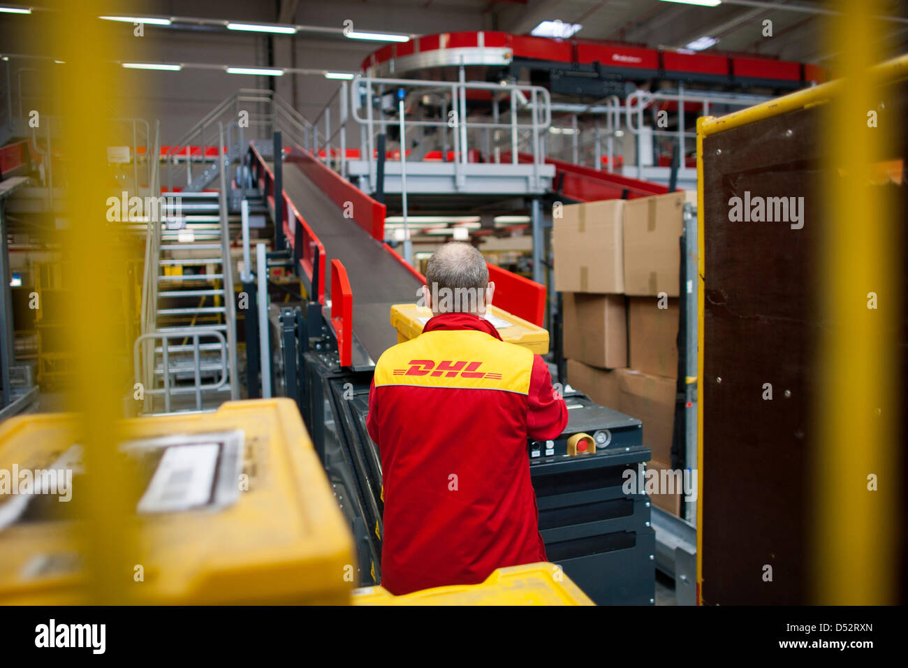 Un dipendente di Deutsche Post DHL mette un pacchetto sulla linea di montaggio in corrispondenza del primo meccanica del punto di consegna a Bochum, Germania, 20 marzo 2013. È il secondo sistema nazionale che legge i pacchetti automaticamente e li distribuisce al trasportatore. Foto: Rolf Vennenbernd Foto Stock