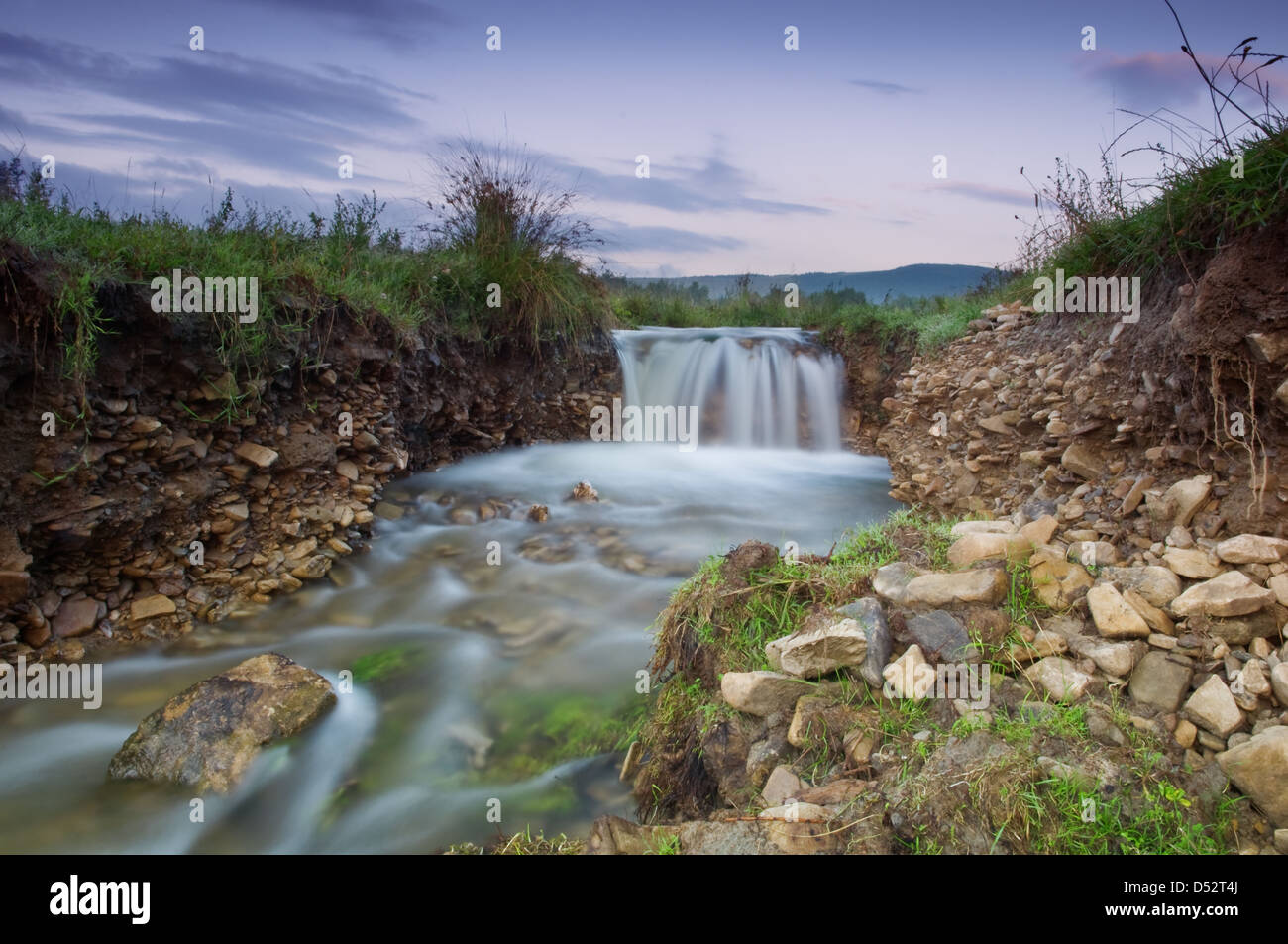 Una piccola cascata sulla mattina tempo Foto Stock