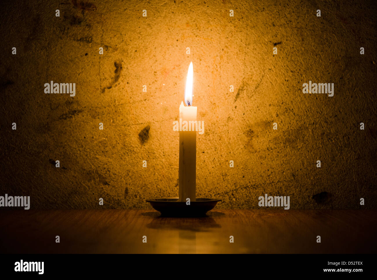 Una candela bruciando, grungy la parete di fondo e vignette Foto stock -  Alamy