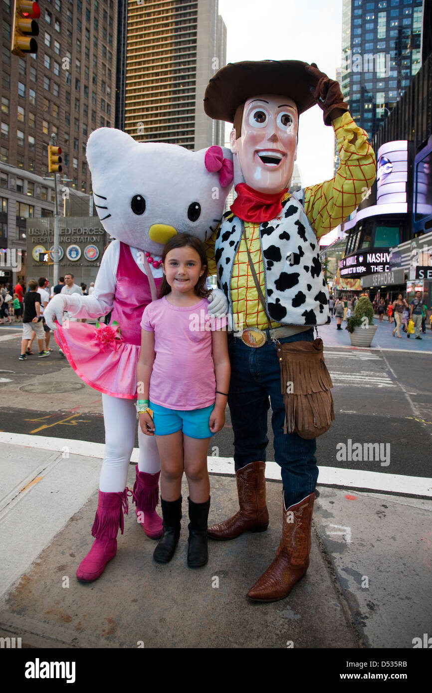 Hello Kitty e Toy Story Woody personaggio dei fumetti costumi in posa con i bambini in Times Square a New York Foto Stock