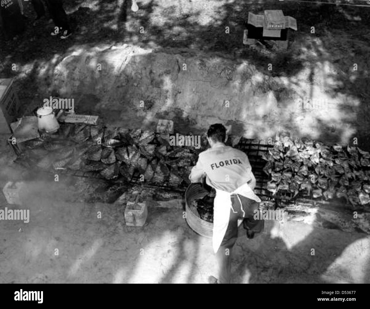 Un cuoco prepara costolette e pollo per un barbecue al Kissimmee River boat-a-cade. L'evento mette in risalto le tradizioni locali che circondano il cibo e gli incontri sul fiume. Foto Stock