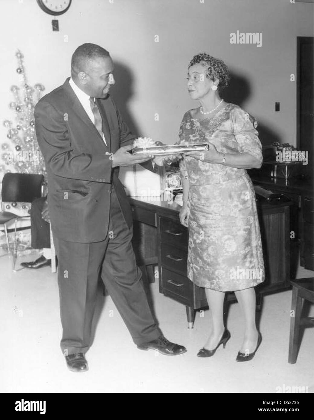 Una festa di Natale alla compagnia Afro-American Life Insurance di Jacksonville, Florida. La foto cattura i dipendenti che celebrano le festività natalizie, mettendo in evidenza un momento di cultura comunitaria e aziendale nella metà del XX secolo. Foto Stock