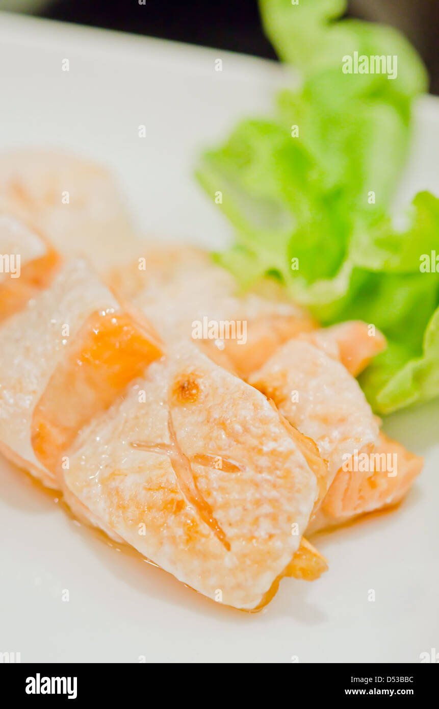 Salmone grigliato servito del ventre con lattuga fresca sul piatto Foto Stock