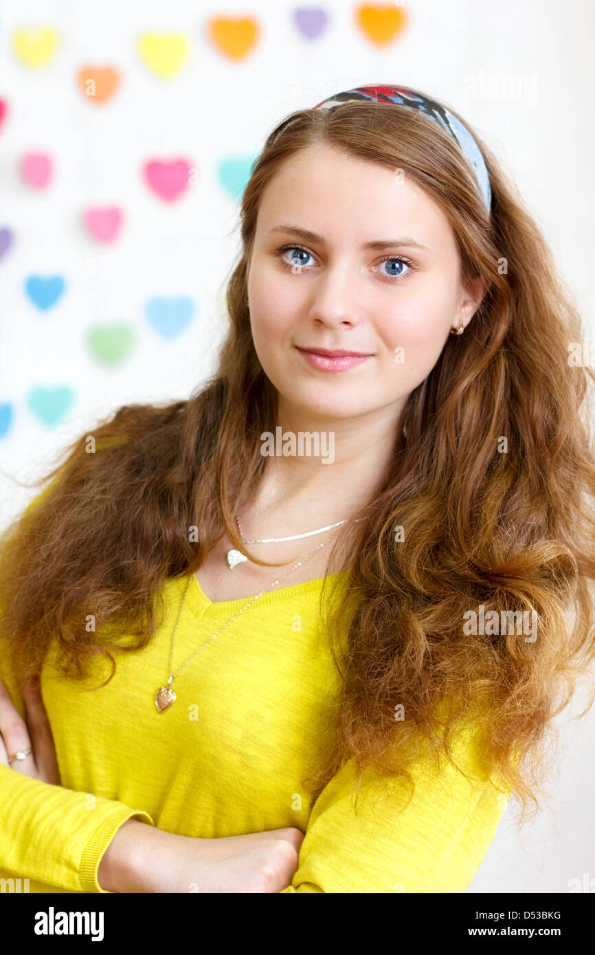 Ritratto di una giovane e bella allegro brunette sorridente ragazza con lunghi capelli rossi in la camicetta giallo Foto Stock