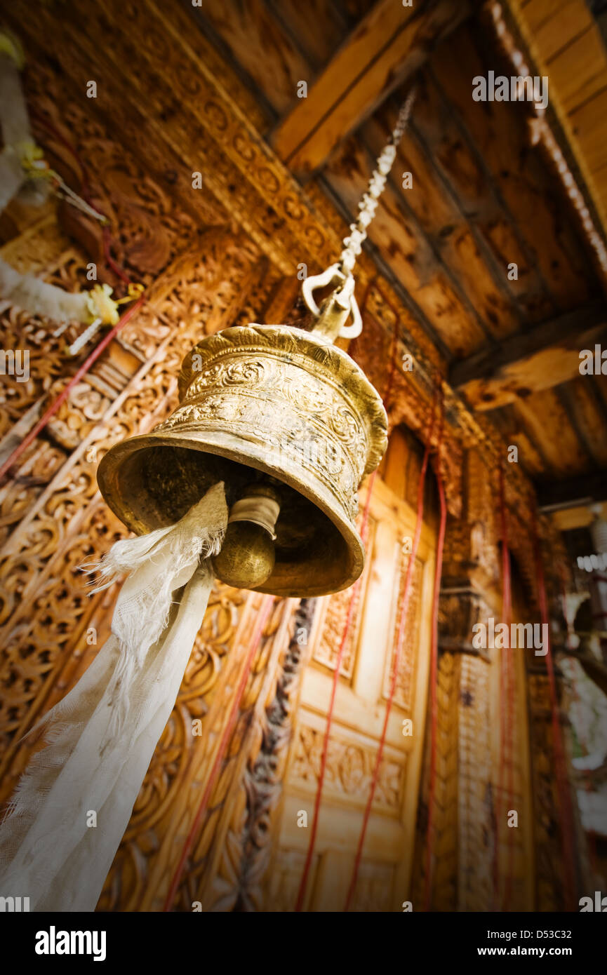 Oro campana tibetana vicino al vecchio tempio Foto Stock