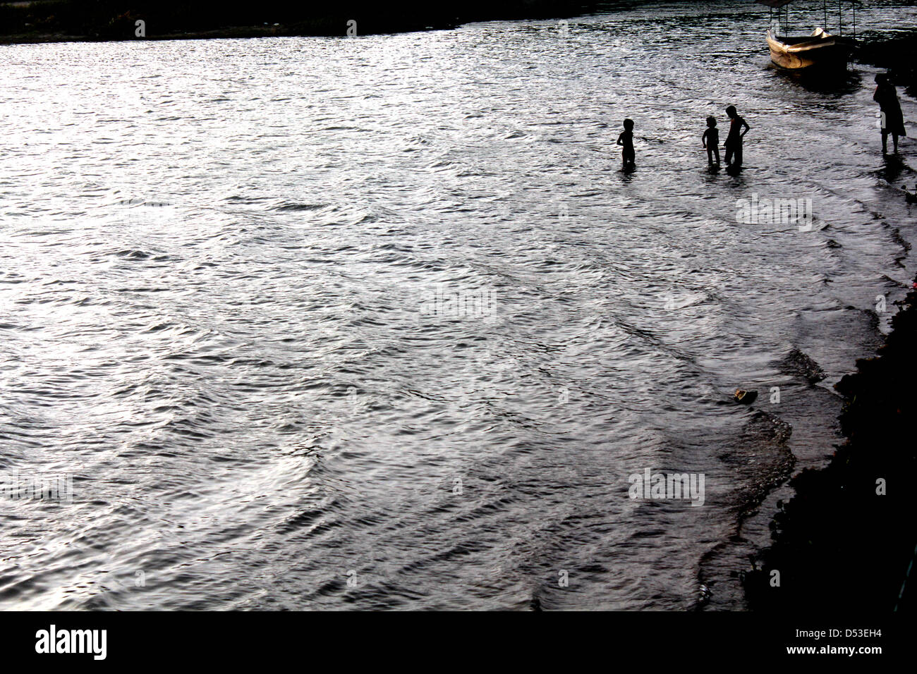 La famiglia gioca nel lago in Tissamaharama, Sri Lanka al tramonto Foto Stock