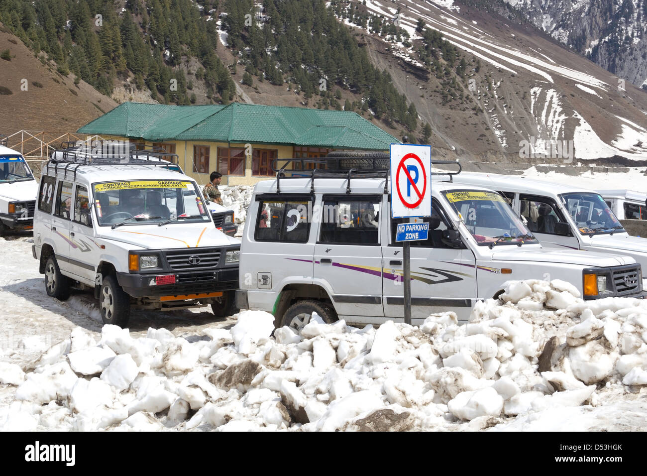 Veicoli turistici parcheggiato presso il parcheggio non accedi Sonmarg, con ghiaccio in primo piano. Uno dei pochi edifici in background. Foto Stock