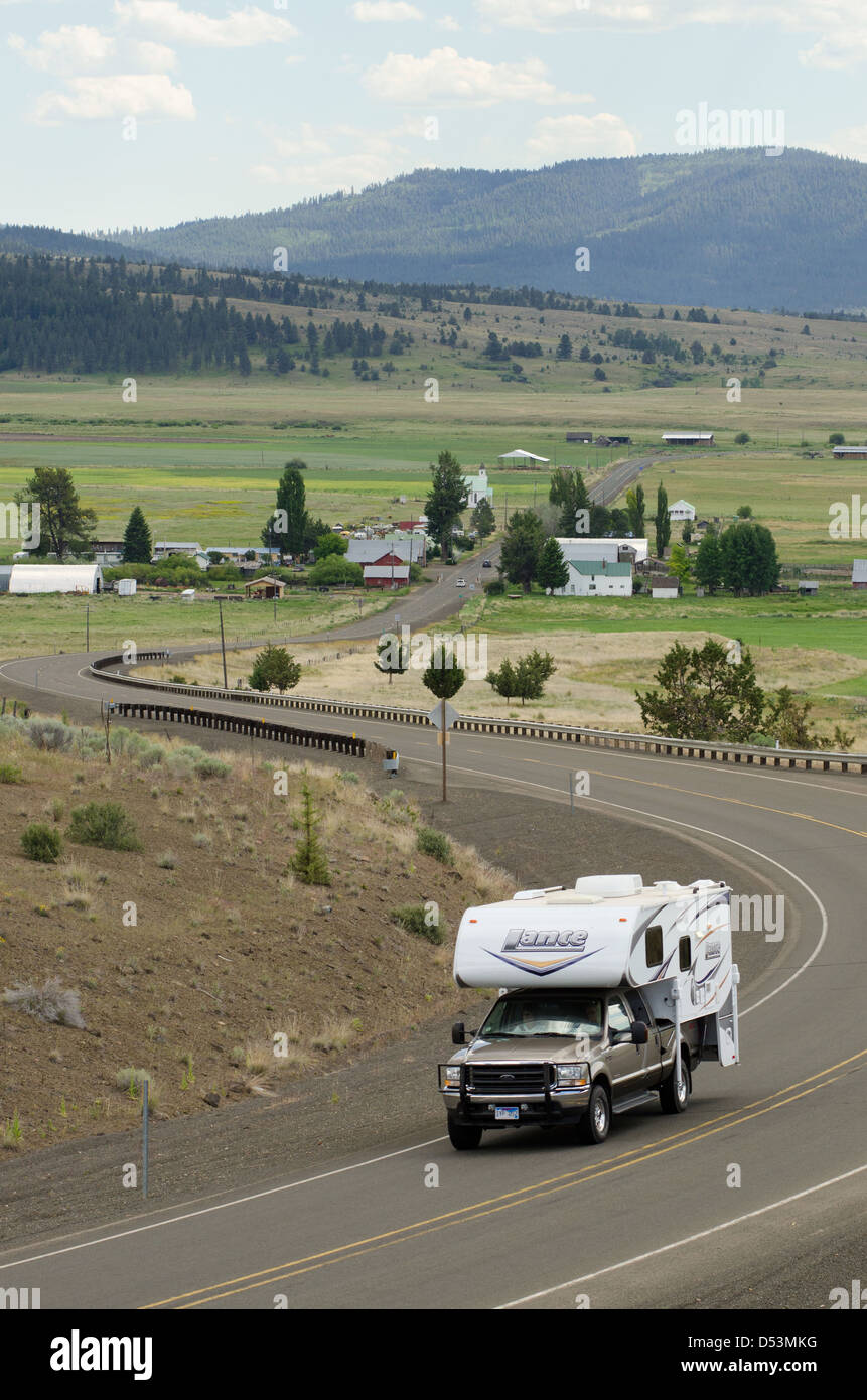 Carrello con camper shell sulla autostrada di avvolgimento al di fuori della piccola comunità di Fox, Oregon. Foto Stock