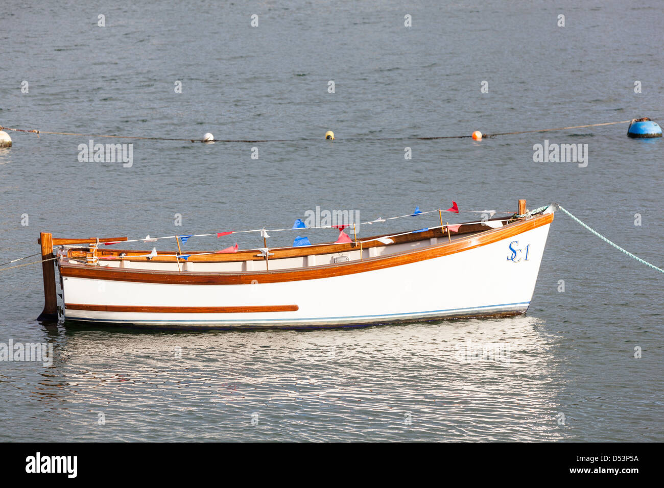 Solitario piccola barca bianca con colorati bunting ormeggiata in un fiume. Foto Stock