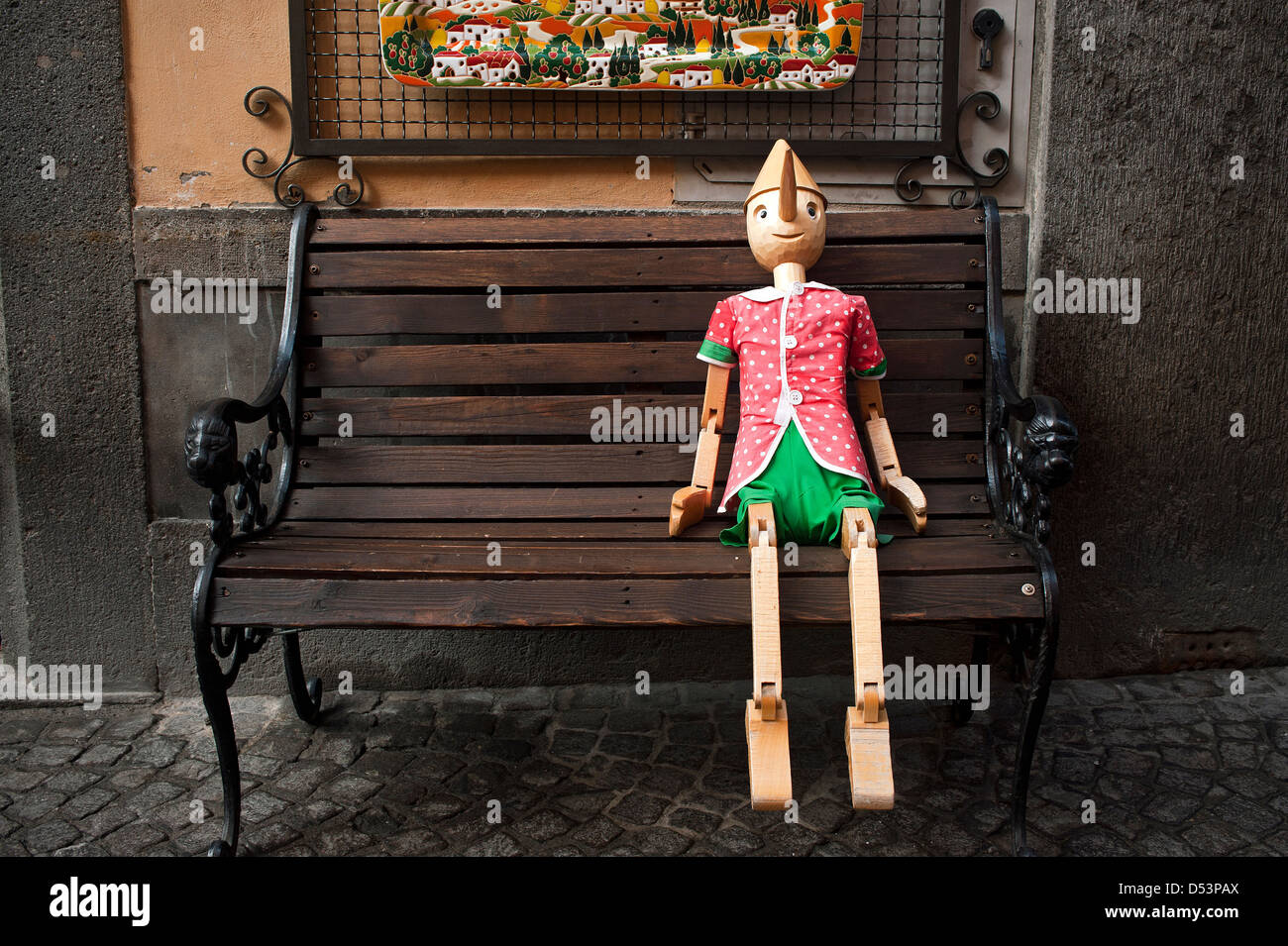 Pinocchio seduto su una panca in legno. Orvieto, Umbria, Italia. Foto Stock