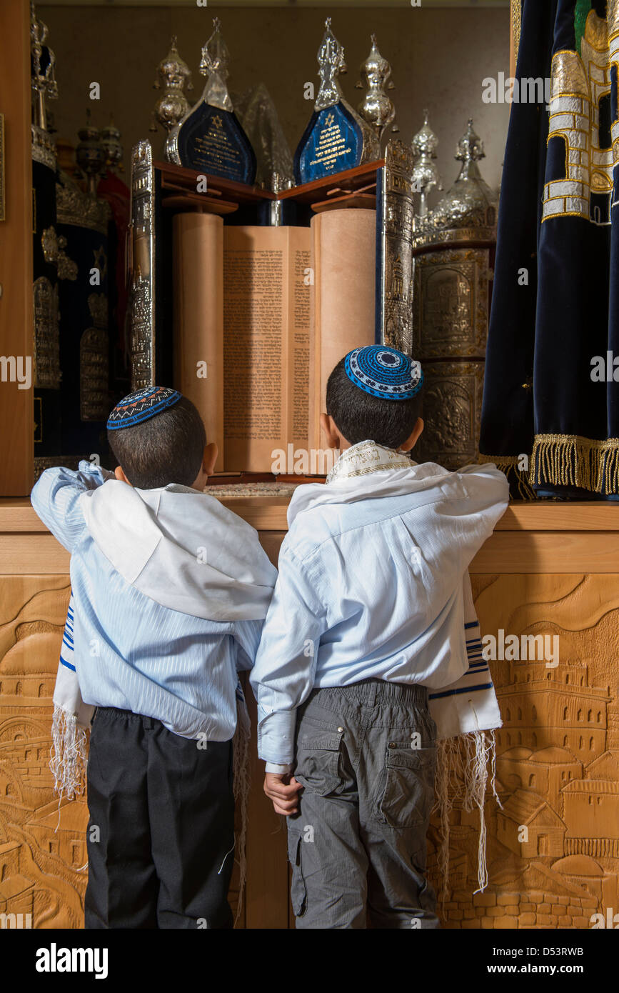 Due ragazzi ebrei nella parte anteriore del santo gli script in una sinagoga Foto Stock