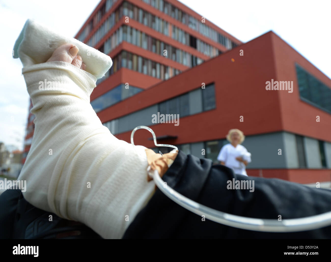 Illustrazione - un'immagine illustrata mostra un paziente con piede bendato davanti all'ospedale di Offenbach, Germania, 22 marzo 2013. La città di Offenbach ha un altra settimana per trovare un acquirente per l'ospedale che è in debito. Foto: Arne Dedert Foto Stock