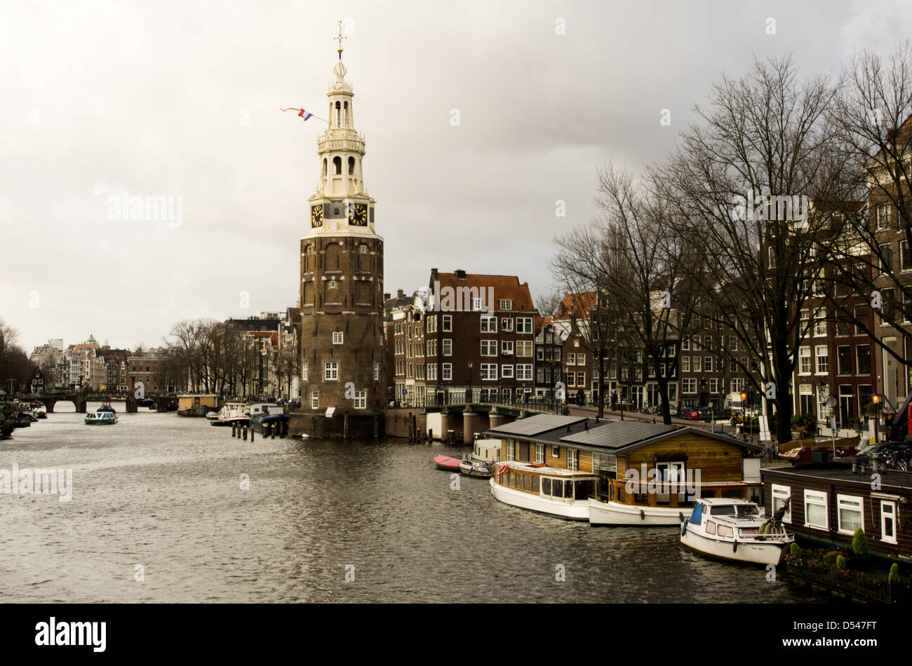 Torre Montelbaanstoren su un canale di Amsterdam. Case-battello lungo il canale. Foto Stock