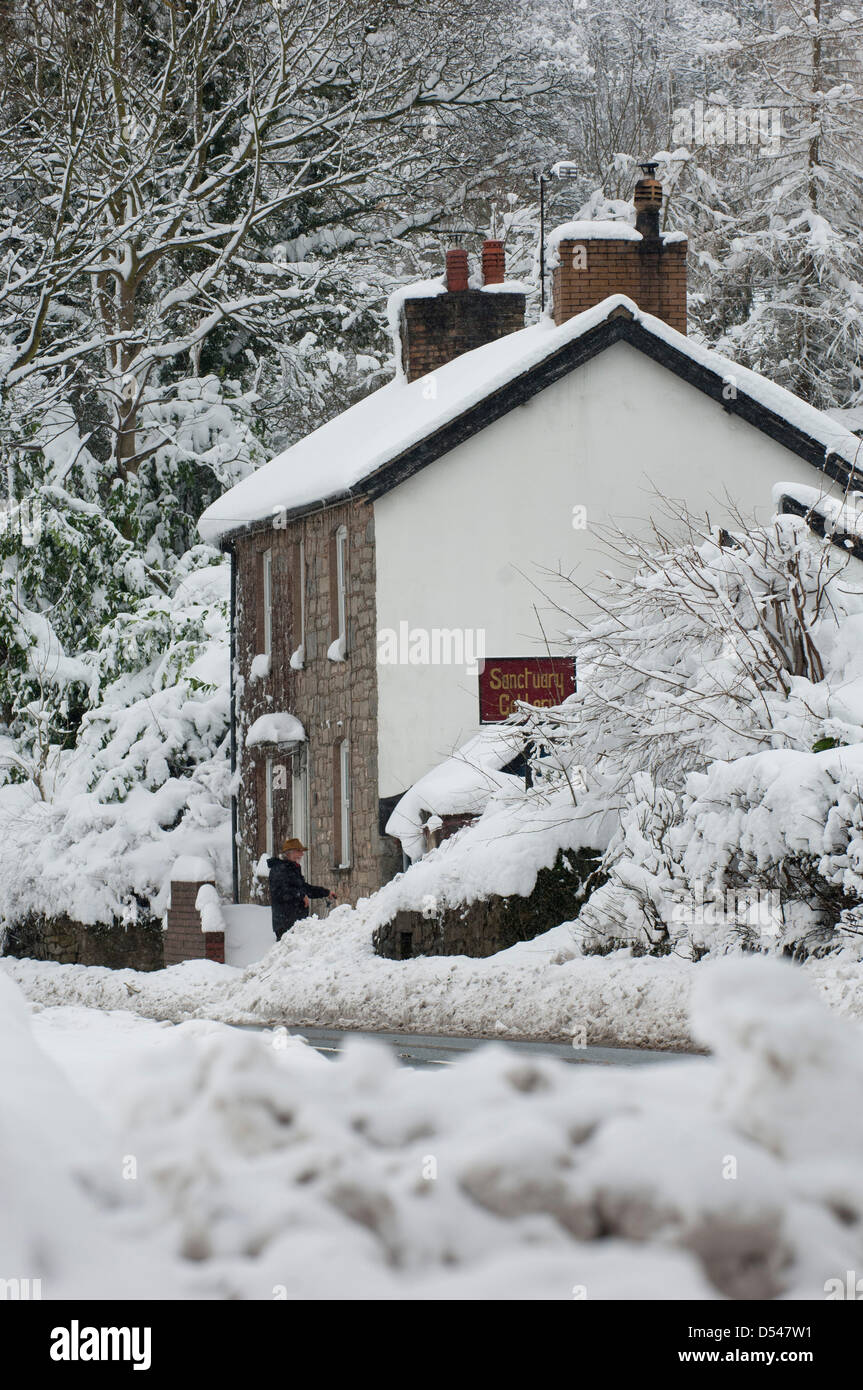 Llangollen, Wales, Regno Unito. Il 24 marzo 2013. La neve è 80cm di profondità in luoghi in Llangollen e molti visitatori intrappolati sulla notte di venerdì, quando la neve pesante fatta strade impraticabili, ora fare un tentativo di scavare le loro auto e tornare a casa. Anche la gente del luogo cercare di ottenere i loro veicoli gratuito per lavoro domani. La neve continua a cadere ma meno pesantemente e le temperature rimangono sotto lo zero. Photo credit: Graham M. Lawrence/Alamy Live News. Foto Stock