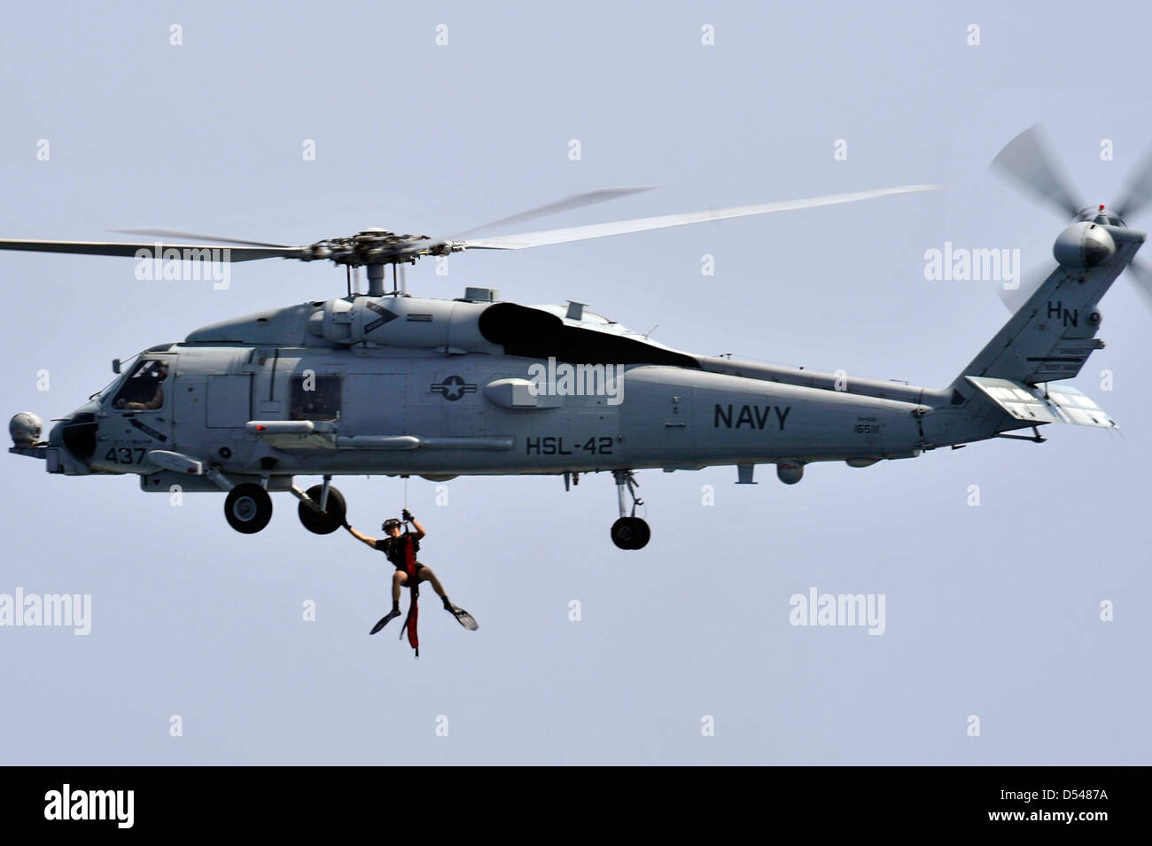 Un US Naval Air equipaggio è sollevato dall'acqua da un SH-60B Mare Hawk elicottero durante una ricerca ed esercitazione di soccorso 11 marzo 2013 nel Mare Arabico. Foto Stock