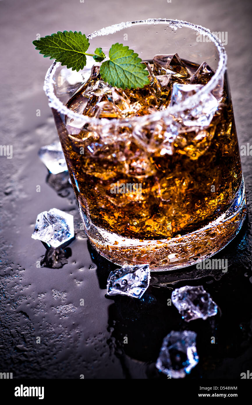 Un bicchiere con un rum, il ghiaccio e la calce e cocktail Foto Stock